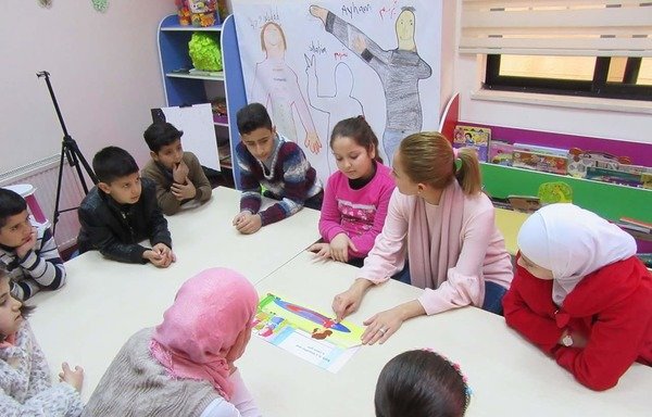 أطفال سوريون يشاركون في جلسة تعديل السلوك يديرها مدرب دعم الصدمات. [حقوق الصورة لمنظمة آسيا للتدريب التنموي]