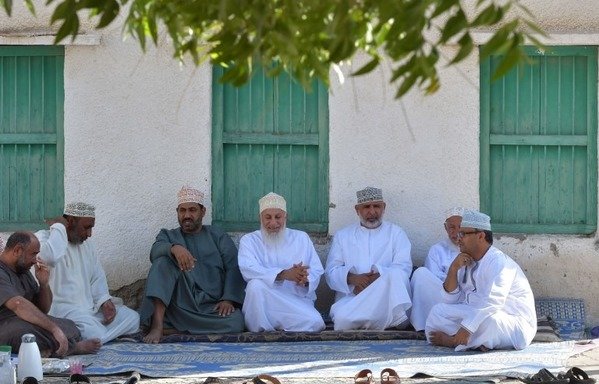 Omani men chat in the small village of Ghala, near Muscat, on October 27th, 2017, as part of their weekly "sabla" meeting where they mediate problems faced by local residents. [Giuseppe Cacace/AFP]
