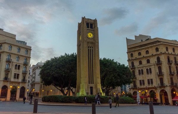 Pedestrians walk near the clock tower in downtown Beirut's Nejmeh square. Full access to the downtown area was restored earlier this month with the removal of concrete barriers. [Photo courtesy of the National News Agency]