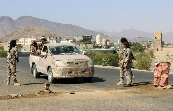 Yemeni tribesmen loyal to the government stop cars at a makeshift security checkpoint along a desert road in the Beihan district in Shabwa province on December 18th, 2017. [Abdullah al-Qadry/AFP]