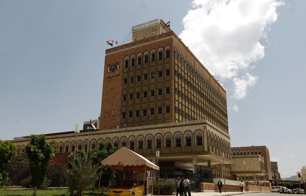 مواطنون يسيرون بالقرب من البنك المركزي في صنعاء بتاريخ 25 آب/اغسطس 2016. يسيطر الحوثيون على بنك صنعاء وقد عمدوا إلى مصادرة حسابات لخصومهم السياسيين. [محمد حويس/وكالة الصحافة الفرنسية]