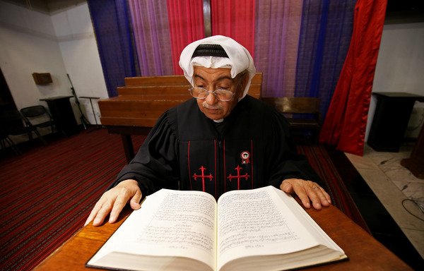 الكاهن عمانويل غريب يقرأ من الإنجيل في الكنيسة الإنجيلية الكويتية في مدينة الكويت يوم 20 شباط/فبراير. كان غريب قد أصبح أول قس عربي خليجي حين تمت رسامته عام 1999.[ياسر الزيات/وكالة الصحافة الفرنسية]