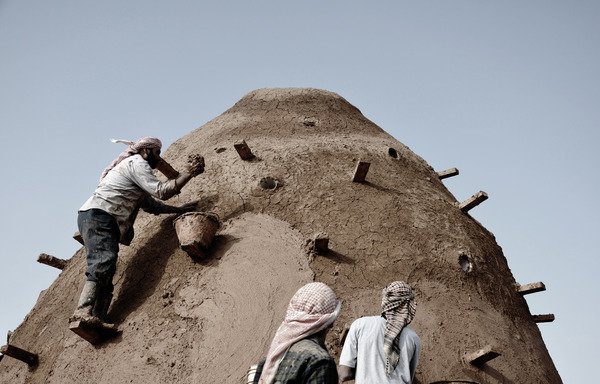 Community members work together to construct a beehive-style classroom in Jordan's Zaatari village. [Photo courtesy of Martina Rubino/EAHR]