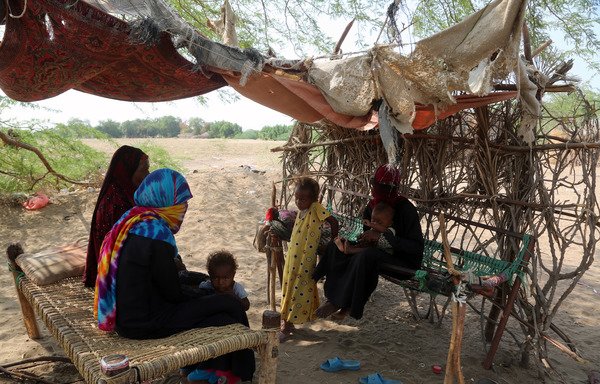 A family sits in a shelter in an impoverished area on the outskirts of the Red Sea port city of al-Hodeida on November 12th, 2017. [Abdo Hyder/AFP]