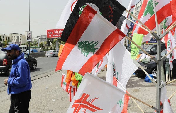 A vendor sells national and party flags on the highway leading to the port of Jounieh, north of Beirut, on May 2nd. [Joseph Eid/AFP]