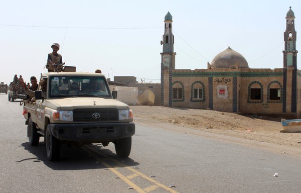 A file photo taken on December 10th, 2017 shows Yemeni fighters loyal to President Abd Rabbu Mansour Hadi riding past a mosque on a road leading to Khokha, which was retaken from the Houthis, about 120 kilometres south of the Red Sea port of al-Hodeidah. [Saleh al-Obeidi/AFP]