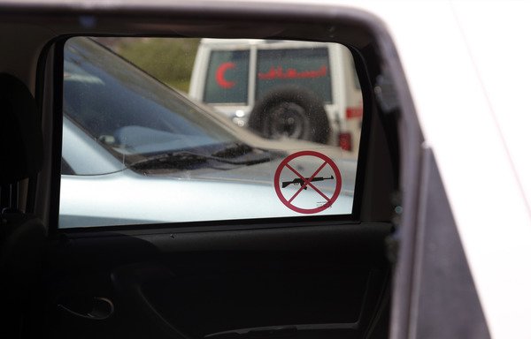 A picture taken April 21st shows a "no weapons allowed" sticker hanging on the window of the damaged International Committee of the Red Cross vehicle that was carrying ICRC employee Hanna Lahoud, parked outside a hospital in Taez. A gunman had opened fire on the vehicle, killing the aid worker with multiple gunshots to the heart. [Ahmad al-Basha/AFP]