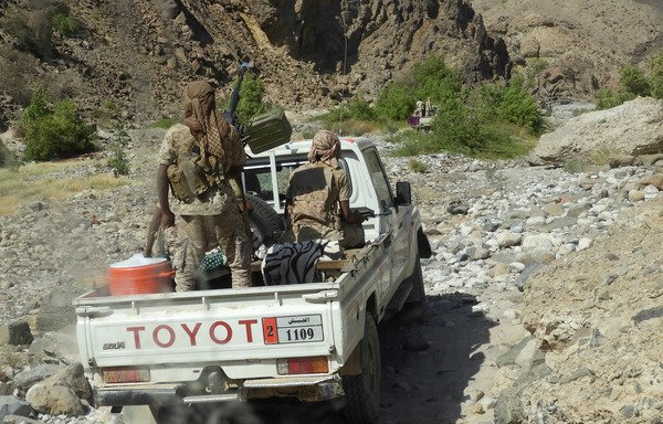Yemeni forces ride in the back of a pickup truck with mounted heavy machine gun while closing in on a suspected location of an al-Qaeda in the Arabian Peninsula leader during an offensive in Wadi al-Masini in Hadramaut province on February 21st. [Saleh al-Obeidi/AFP]