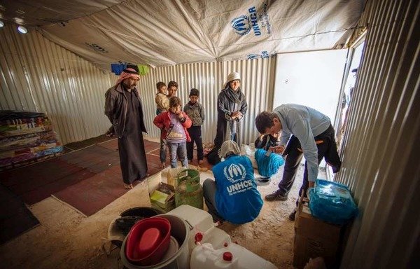 موظفو المفوضية السامية للأمم المتحدة لشؤون اللاجئين يقدمون المساعدات لأسر سورية لاجئة في مخيم الأزرق. [حقوق الصورة للمفوضية السامية لشؤون اللاجئين]