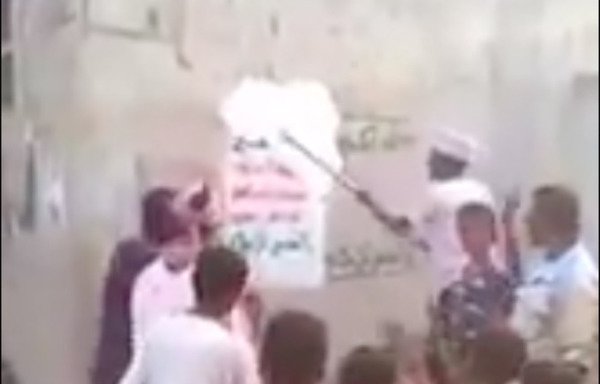 A screenshot from a video circulated online shows residents painting over Houthi slogans on the walls of an area on the outskirts of the port city of al-Hodeida.