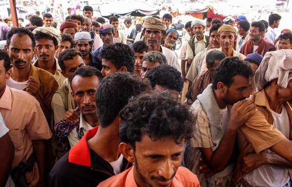 Displaced Yemenis who fled battles in the Red Sea province of al-Hodeida queue to receive food aid in the Hajjah province district of Abs on June 24th. [Essa Ahmed/AFP]