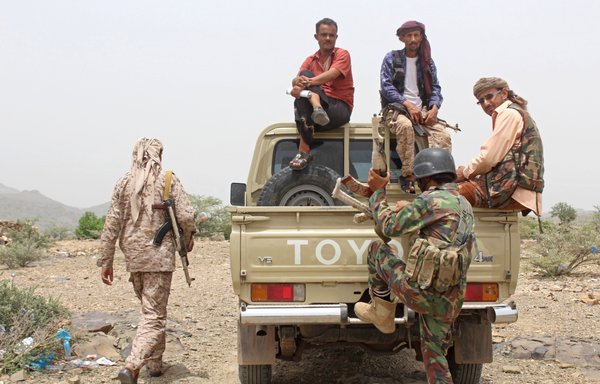 Pro-government fighters sit on the back of an armed truck as allied forces take over Houthi bases on the frontline of Kirsh between the provinces of Taez and Lahj on July 1st. [Saleh al-Obeidi/AFP]