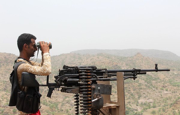 A Yemeni pro-government fighter looks through binoculars as Yemeni forces backed by the Arab coalition take over Houthi bases on the frontline of Kirsh between the province of Taez and Lahj in southwestern Yemen on July 1st. [Saleh al-Obeidi/AFP]