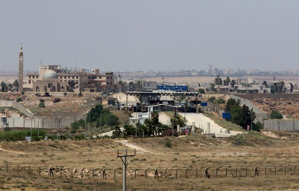 A general view taken from Jordan's Mafraq governate on July 7th shows the Jaber border crossing a day after the Syrian regime retook the Syrian side of the crossing, known as Nassib. [Khalil Mazraawi/AFP]