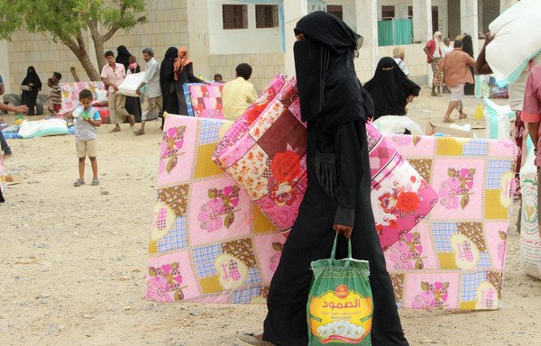 Displaced Yemenis from al-Hodeidah receive humanitarian aid donated by a Turkish NGO in the northern Yemeni district of Hajjah province on August 6th. [Essa Ahmed/AFP]