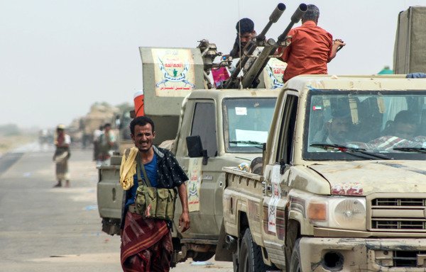 Yemeni fighters from the pro-government Giant Brigades gather with armed pick-up trucks and armoured vehicles on the side of a road during the al-Hodeidah offensive on June 21st. [Saleh al-Obeidi/AFP]