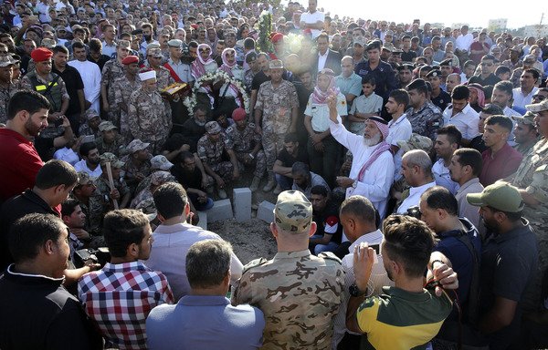 Jordanian forces and relatives of Sgt. Hisham Aqarbeh, a member of the anti-terrorist unit who was killed in a Saturday (August 11th) attack, attend his funeral on Sunday in the town of Birayn. [Khalil Mazraawi/AFP] 