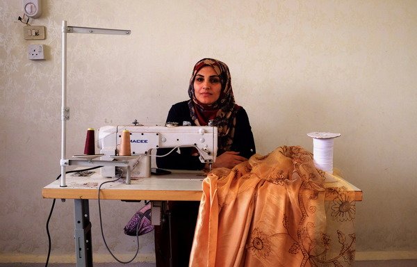 سلوی نقارش با خرید چرخ خیاطی که از محل درآمد شرکت در برنامه «اقدام علیه گرسنگی» به دست آورده است، کار می کند. [آیدا برنت کارگیل/ اقدام علیه گرسنگی]