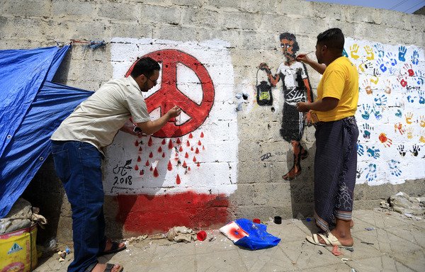 Yemeni artists paint a pro-peace graffiti on a wall in the capital Sanaa on August 16th, as they call for peace and tolerance and rejecting the ongoing conflict in the Arab country. [Mohammed Huwais/AFP]