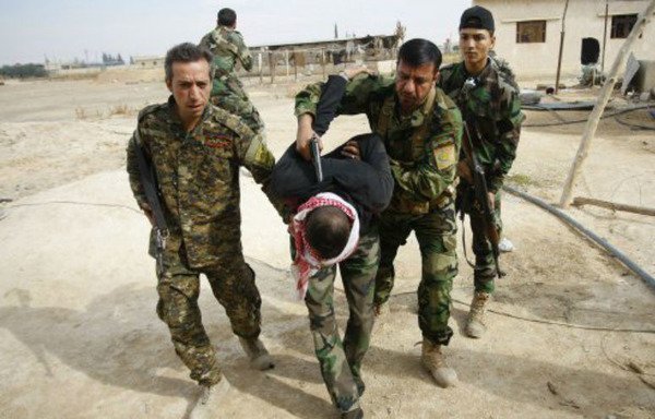 عناصر من ميليشيات تابعة للحرس الثوري الإيراني في محافظة دير الزور السورية خلال اعتقالها لأحد جنود الجيش السوري. [حقوق الصورة لجميل العبد]