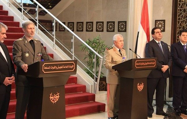 The Syrian and Iranian defence ministers take part in a press conference following the signing of a new military agreement. [Photo via Syrian and Iranian websites, circulated on social media]