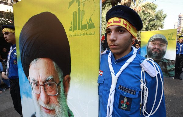 Supporters of Lebanese militia Hizbullah hold posters of Iran's Supreme leader Ayatollah Ali Khamenei (L) and the movement's slain former military commander, Imad Mughniyeh, during a parade to mark Ashura, on September 20th in Beirut. A new US State Department report identified Iran as the leading state sponsor of terrorism with a "near-global reach". [Anwar Amro/AFP]