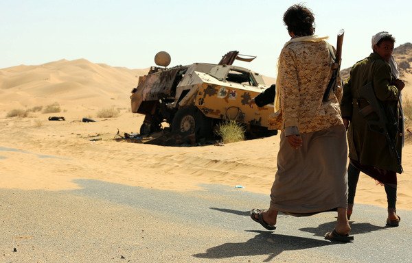 Yemeni tribesmen from the Popular Resistance Committees, loyal to Yemen's president, disembark from a pickup truck carrying an anti-aircraft gun as they park on a desert road in Beihan, Shabwa province, on December 18th, 2017. [Abdullah al-Qadry/AFP]
