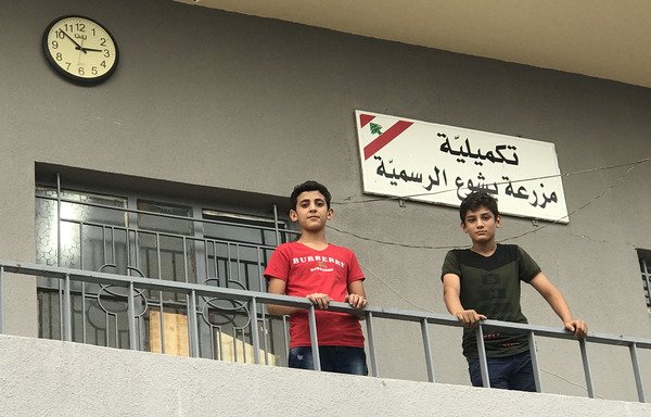 أطفال سوريون لاجئون ينتظرون للتسجيل في المدرسة التكميلية الرسمية في منطقة مزرعة يشوع في لبنان. [نهاد طوباليان/المشارق]