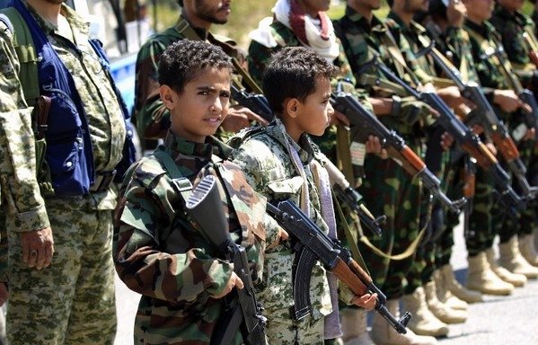 Yemeni children accompanied by their fathers hold weapons during a gathering in Sanaa to show support for the Houthis in Sanaa on September 27th, 2018. The Arab Parliament on October 3rd has called for urgent measures against the Houthis’ forced recruitment of children in Yemen, saying the militia has been using them as fuel in their war against the country's legitimate authority. [Mohammed Huwais/AFP]