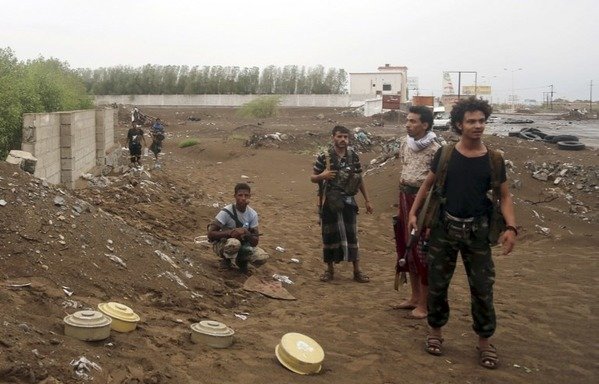 Houthi fighters stand near landmines that have been removed in the city of al-Hodeidah on September 13th, 2018. The Washington Institute has said that the Houthis are using landmines today "at an astonishingly high rate" as they withdraw from areas in Aden, Taez, Marib and, more recently, along Yemen's western coast. [Stringer/AFP]