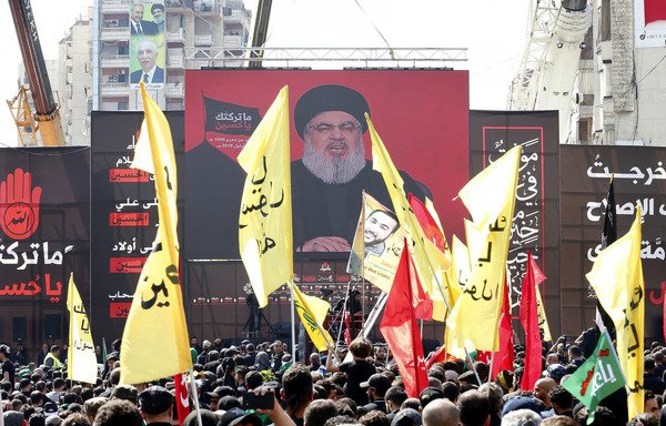 Supporters of Lebanon's Hizbullah gather near a poster of Hassan Nasrallah during a ceremony to mark Ashura on September 20th in Beirut. [Anwar Amro/AFP]