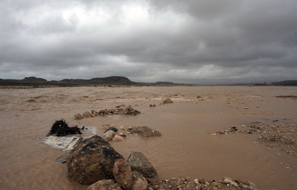 A picture taken on October 14th shows flooding in the Adonab valley near Salalah in southern Oman during Tropical Storm Luban. At least three people were killed and 33 injured by flash flooding in Yemen and Oman caused by the storm. [Mohammed Mahjoub/AFP]