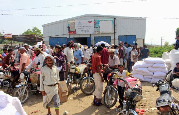 نازحون يمنييون من المدينة الساحلية الحديدة يتلقون مساعدات إنسانية من برنامج الغذاء العالمي في شمالي محافظة حجة، يوم 25 أيلول/سبتمبر الماضي. [عيسى أحمد/وكالة الصحافة الفرنسية]