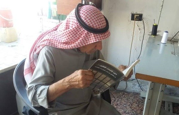 An elderly man reads "When prisons speak", a new book by Syrian author Ghada Bakir, which tells the stories of detainees who died under torture in Syrian regime prisons. [Photo courtesy of Ghada Bakir]