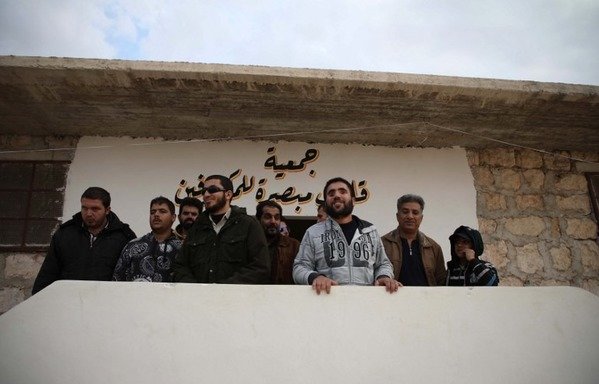 Ahmad Talha (3rd-R), a former Syrian opposition fighter who lost his sight as a result of a gunshot wound, poses for a picture with other students from the association for the blind on November 10th, 2018, in the opposition-controlled town of Anjara, in the western Aleppo countryside. [Aaref Watad/AFP]