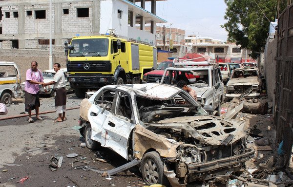A photo taken March 13th in the port city of Aden shows Yemenis inspecting the wreckage of a car in the aftermath of a suicide bombing claimed by ISIS, which hit UAE-trained Yemeni troops. [Saleh al-Obeidi/AFP]