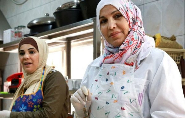 زنان اردنی و سوری مهارتهای آشپزی و دستورپخت غذا را در آشپزخانه انجمن توسعه خانواده ها در عمان سهیم می شوند. [عکس با کسب اجازه از آکسفام]
