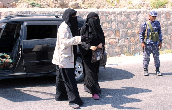 A female member of the Yemeni forces leads a woman away to inspect her bag in privacy at a checkpoint in the Hadramaut provincial capital of al-Mukalla, a former al-Qaeda stronghold, on November 30th. [Saleh al-Obeidi/AFP]