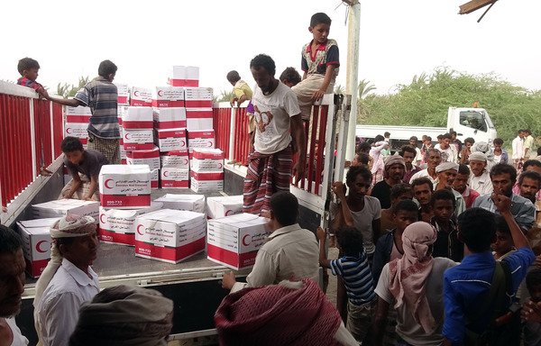 Yemenis drop off boxes of humanitarian aid provided by the Emirati Red Crescent in the coastal town of Mujailis, south of al-Hodeidah city, on June 6th. [Nabil Hassan/AFP]