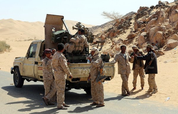 Yemeni tribesmen from the Popular Resistance Committees, loyal to Yemen's legitimate government, disembark from a pickup truck carrying an anti-aircraft gun as they park on a desert road in Beihan in Shabwa province, on December 18th, 2017. [Abdullah al-Qadry/AFP]