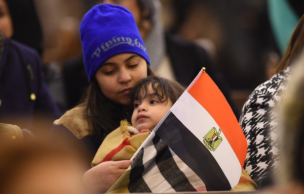 مصلون مسيحيون يرفعون العلم المصري أثناء مشاركتهم في قداس الميلاد للأقباط الأرثوذكس وحفل افتتاح كاتدرائية ميلاد المسيح يوم الأحد، 6 كانون الثاني/يناير. [محمد الشاهد/وكالة الصحافة الفرنسية]
