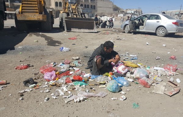 A Yemeni man picks through the rubbish for food scraps to salvage during the growing humanitarian crisis. [Nabil Abdullah al-Tamimi/Al-Mashareq]