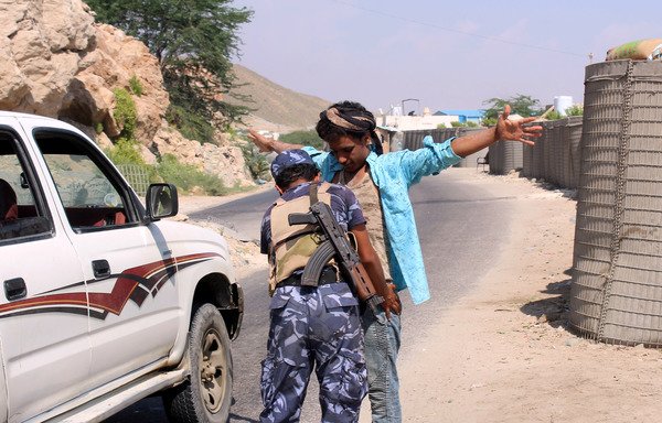 A member of the Yemeni security forces frisks a man at a checkpoint in the former al-Qaeda in the Arabian Peninsula (AQAP) bastion of al-Mukallah in Yemen's coastal southern Hadramaut province, on November 30th, 2018. [Saleh al-Obeidi/AFP]