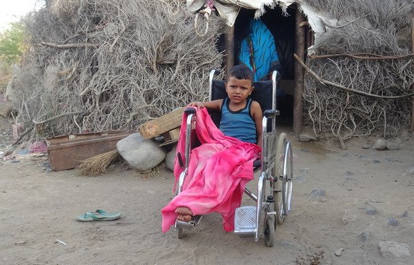 Abdullah, 7, who was wounded in a landmine explosion in Yemen's Taez province, sits in a wheelchair outside his family's shelter in al-Hamili district on November 29th. [AFP]