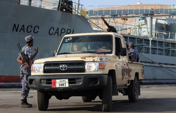 Yemeni pro-government forces stand guard by a ship docked in al-Mukalla port, southwestern Yemen, on November 29th, 2018. [Saleh al-Obeidi/AFP]