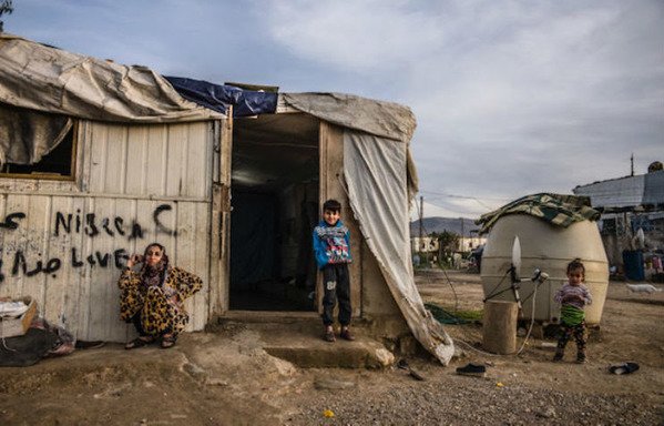 امرأة وأطفال سوريون في مخيم في لبنان في تشرين الثاني/نوفمبر. ويستخدم العديد من العائلات اللاجئة استراتيجيات للتكيف مع ديونها، يمكن أن تضر بالأطفال حسبما أظهرته دراسة جديدة. [نهاد طوباليان/المشارق]