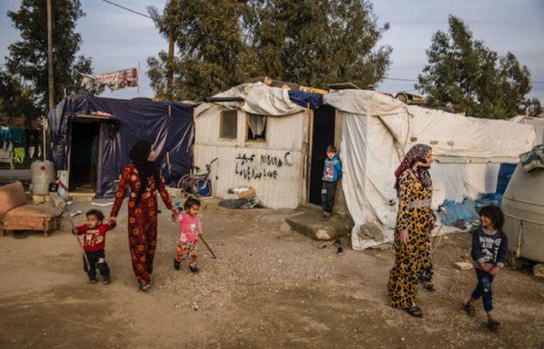 أفراد عائلات لاجئة سورية يمشون في مخيم في لبنان في تشرين الثاني/نوفمبر. وأظهرت دراسة جديدة أن الوضع لا يزال صعبا لمعظم العائلات السورية اللاجئة في لبنان. [نهاد طوباليان/المشارق]