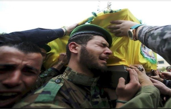 Hizbullah fighters weep during the funeral of a comrade who was killed in Syria. [Photo circulated on social media]