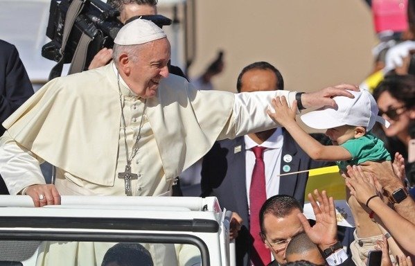 البابا فرنسيس يبارك طفلا عند وصوله لترأس قداس لما قدر بـ 170 ألف كاثوليكي في استاد مدينة زايد الرياضية بأبو ظبي في 5 شباط/فبراير. [كريم صاحب/وكالة الصحافة الفرنسية]