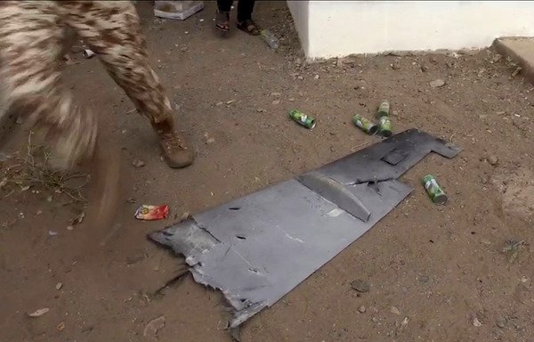 A screenshot taken from a video obtained by AFPTV shows a Yemeni soldier walking past one of the wings of a Houthi drone that exploded above Yemen's al-Anad airbase in the southern province of Lahj on January 10th. [Nabil Hasan/AFP/AFPTV]